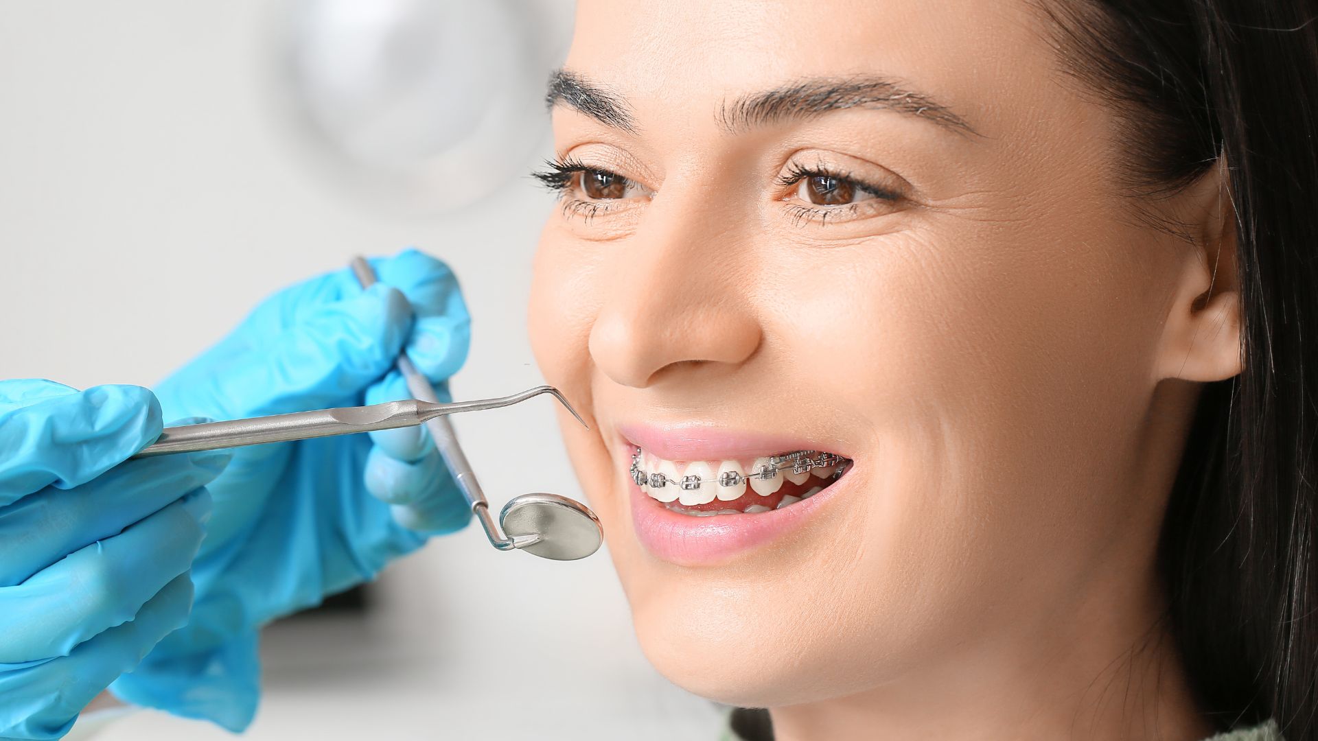 Orthodontic treatment in Turkey with Dentique, showing a smiling patient wearing dental braces during a professional orthodontic check-up at a modern clinic.