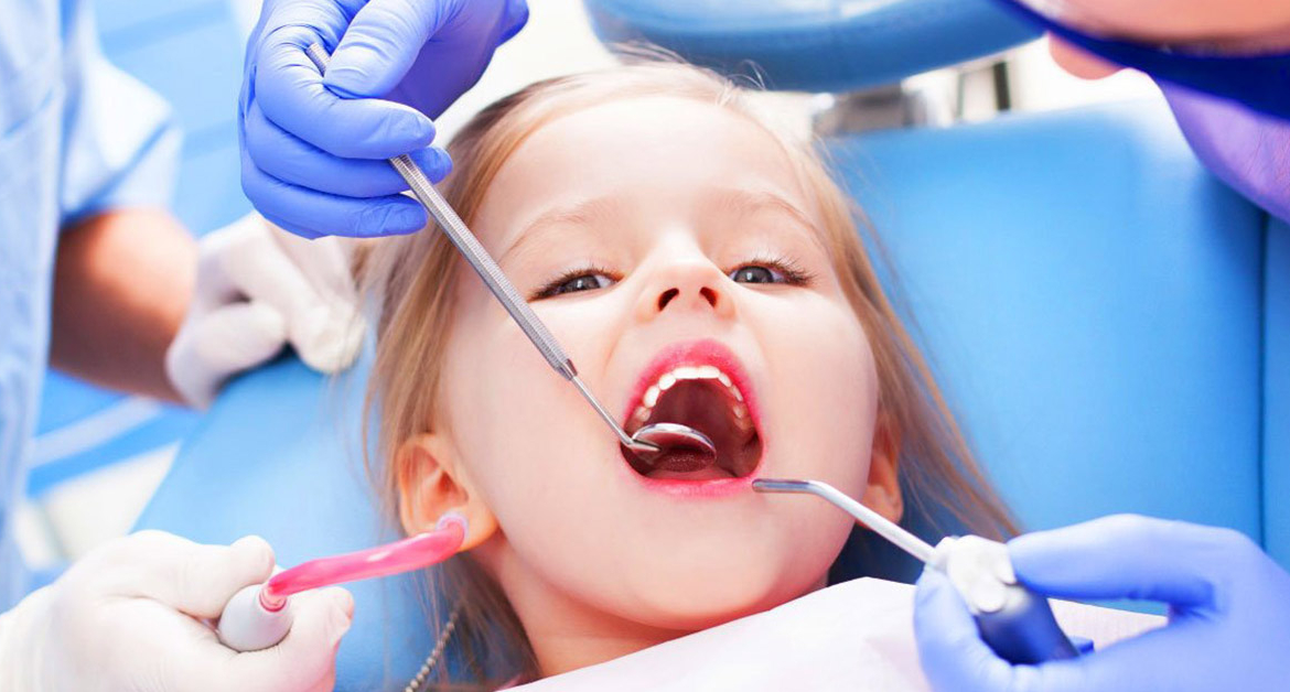 Pediatric dentistry in Turkey with Dentique, showing a young child receiving a gentle dental examination by professional dentists in a modern, child-friendly clinic.